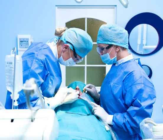 an oral surgeon placing dental implants in a patient's mouth