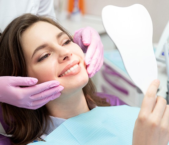 Cosmetic dentistry patient looking at her smile in mirror