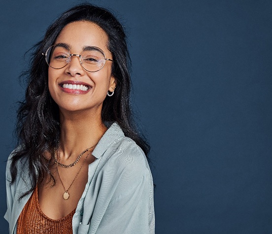 Confident, smiling young woman against dark background