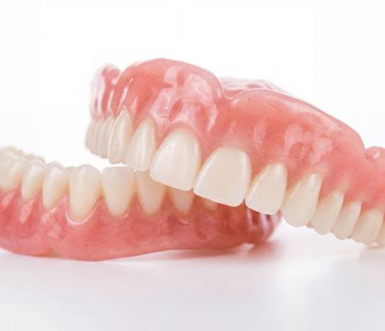 Full set of dentures against neutral background