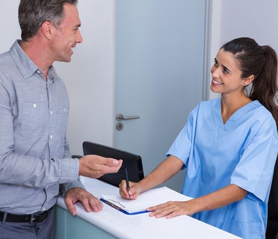 Dental team member assisting patient at front desk
