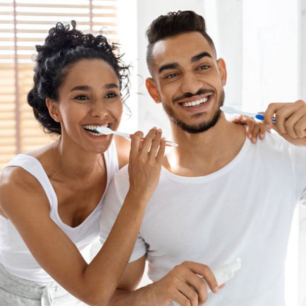 Young couple brushing their teeth in bathroom