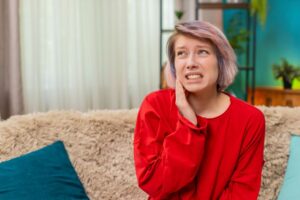 Young woman with a toothache, wearing worried expression 