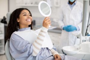 Dental patient admiring her teeth in the mirror